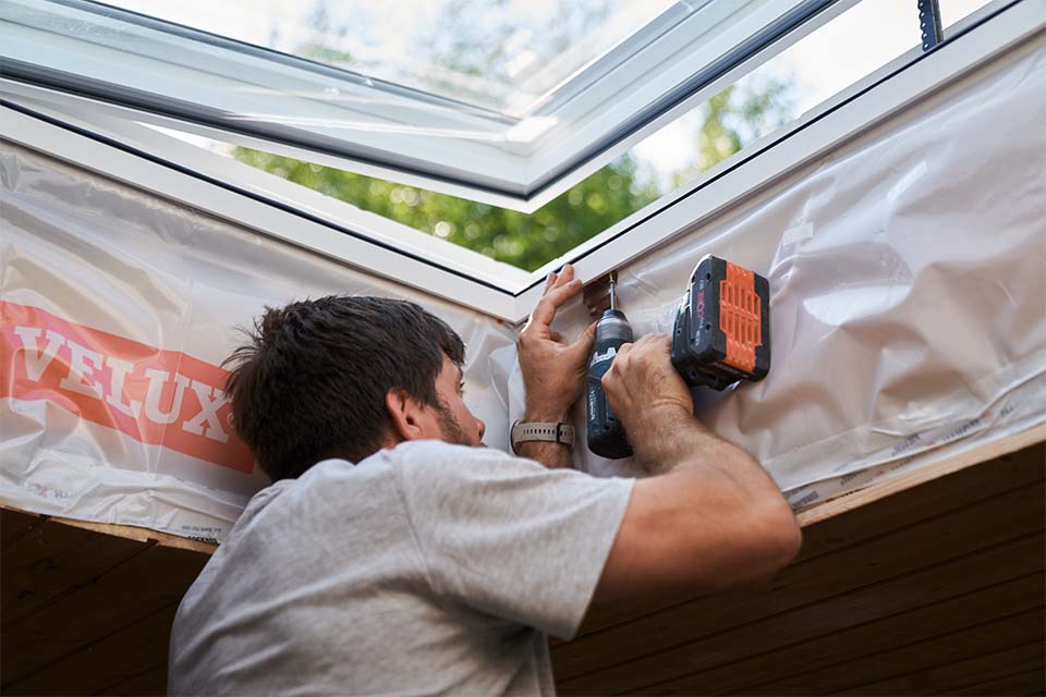 Håndværker isætter Velux-ovenlysvindue